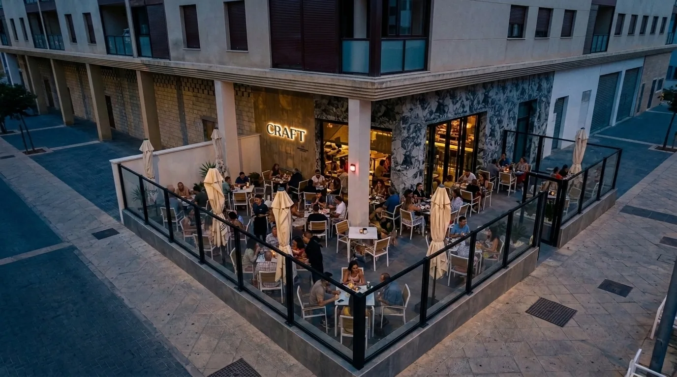 Vista aérea de la terraza de Craft al anochecer, llena de gente, en la esquina de la calle Miguel de Molina